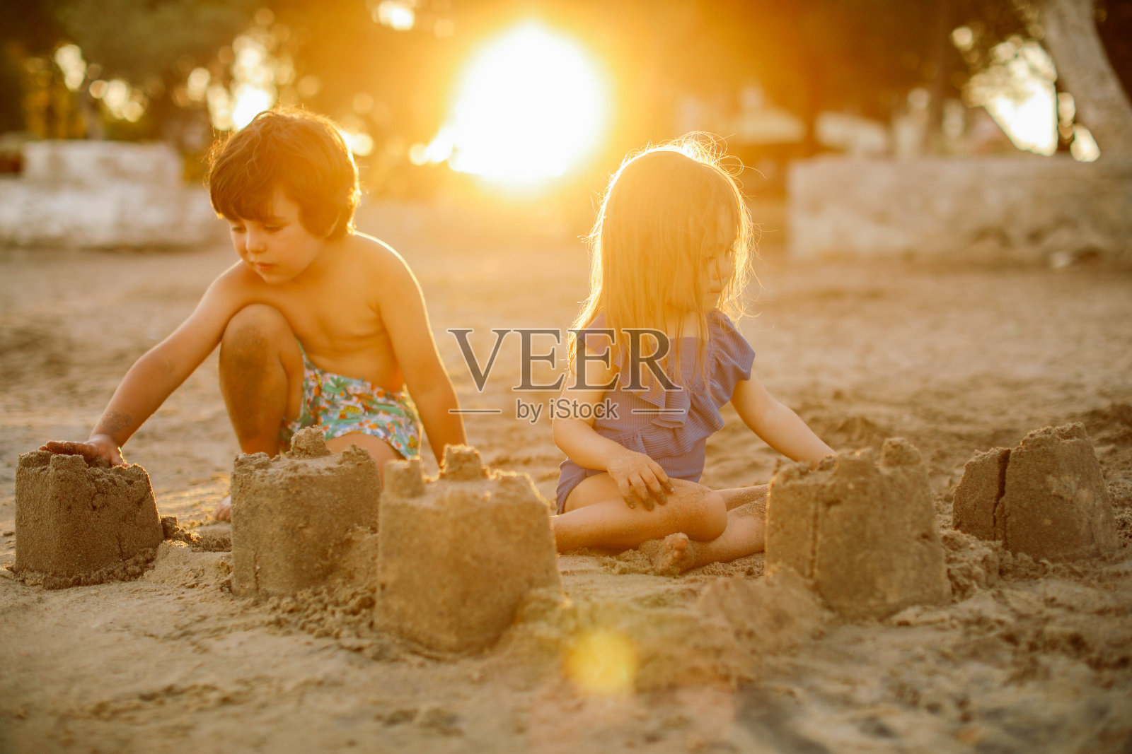 快乐的笑着蹒跚学步的男孩和女孩在沙滩上玩耍照片摄影图片