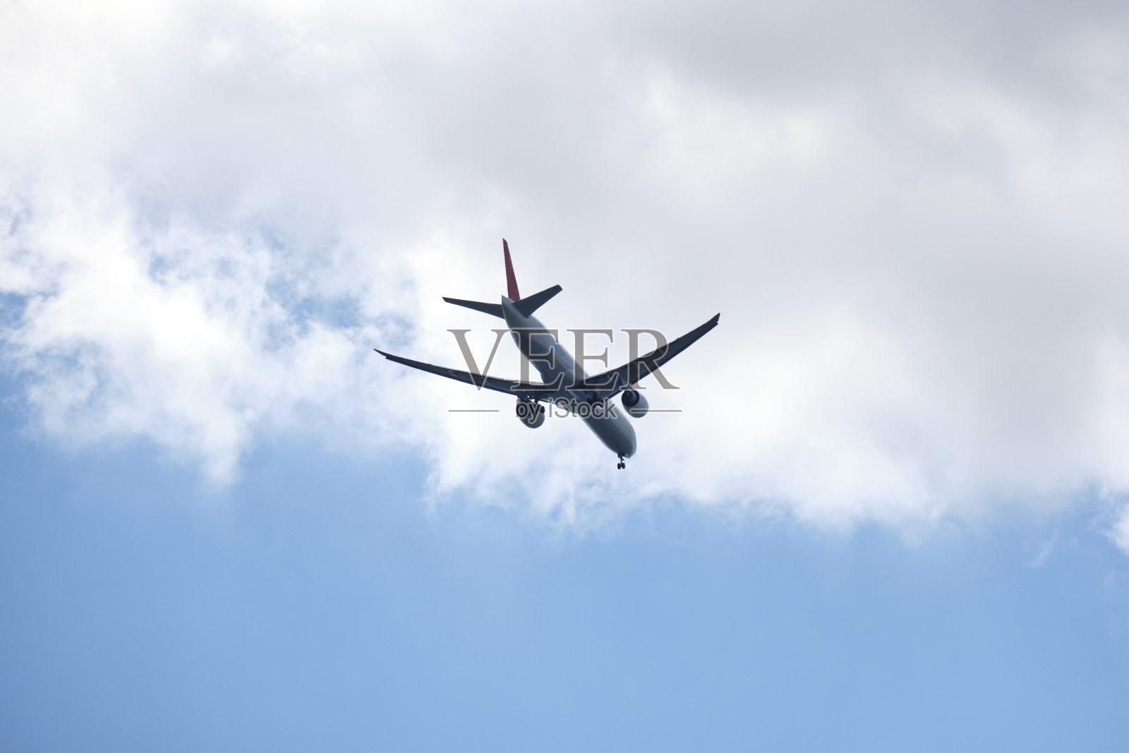 从下面白色和蓝色的飞机与蓝色和多云的天空飞行照片摄影图片