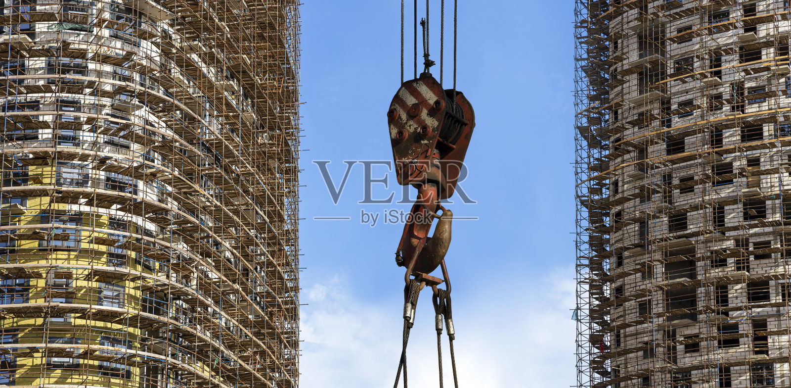 俄罗斯莫斯科，建筑起重机吊钩与脚手架(新住宅综合体)背景下的多层建筑照片摄影图片