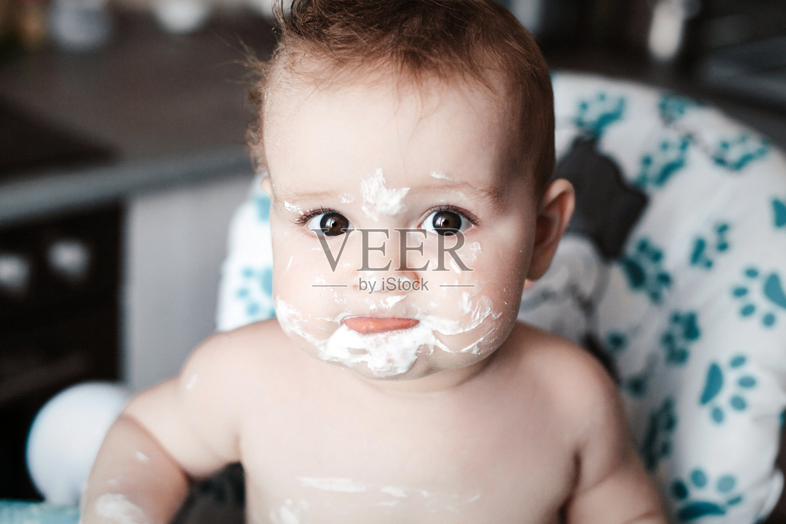 近距离的肖像可爱的凌乱的婴儿谁吃甜食的第一次照片摄影图片