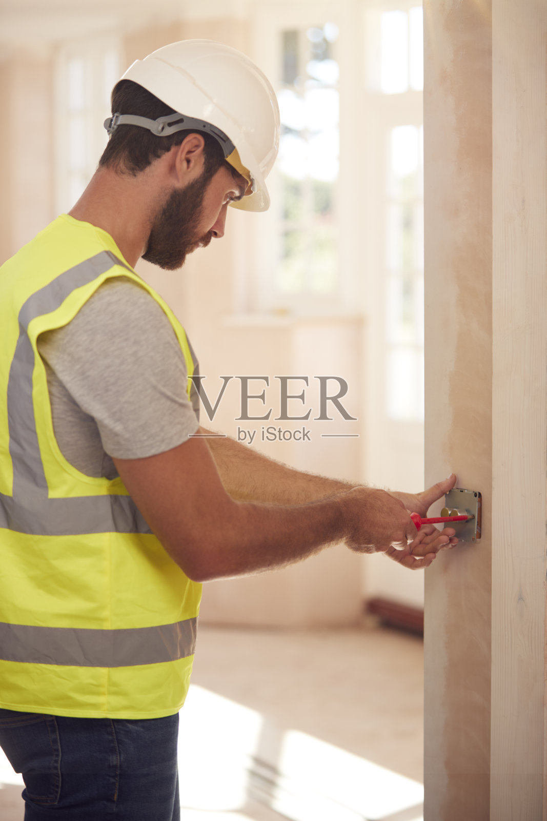 电工戴安全帽在新建物业安装电灯开关照片摄影图片