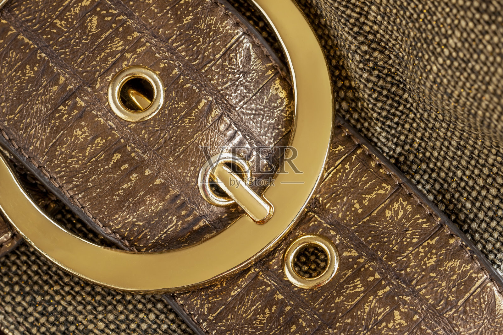 皮包的部分棕色与金色的包扣，金属细节特写，背景。没有名字，没有标识照片摄影图片