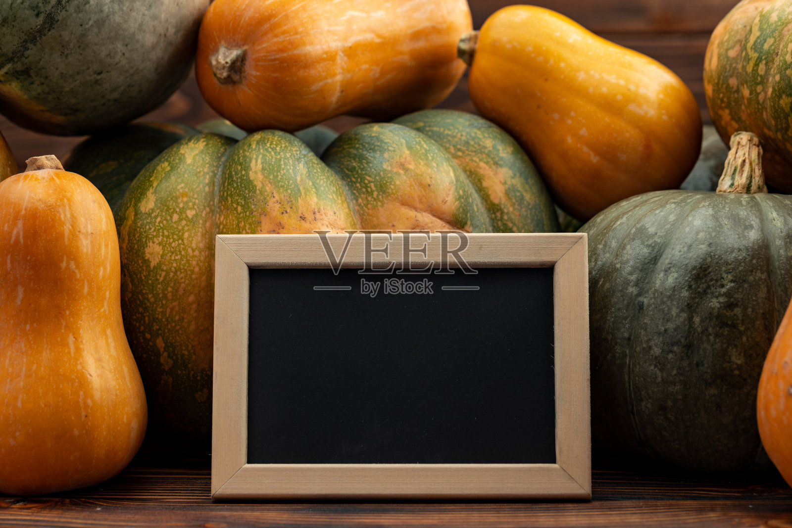 小黑板在一堆南瓜旁边照片摄影图片