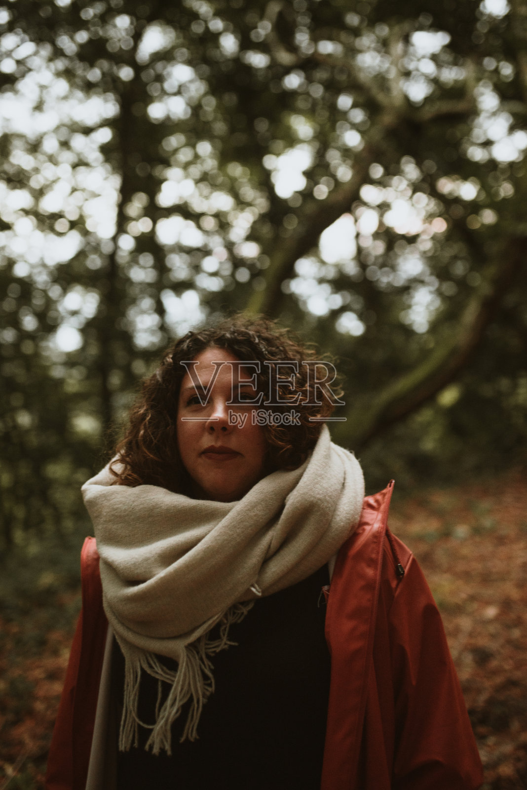 森林里一位戴着围巾的年轻女子的肖像照片摄影图片