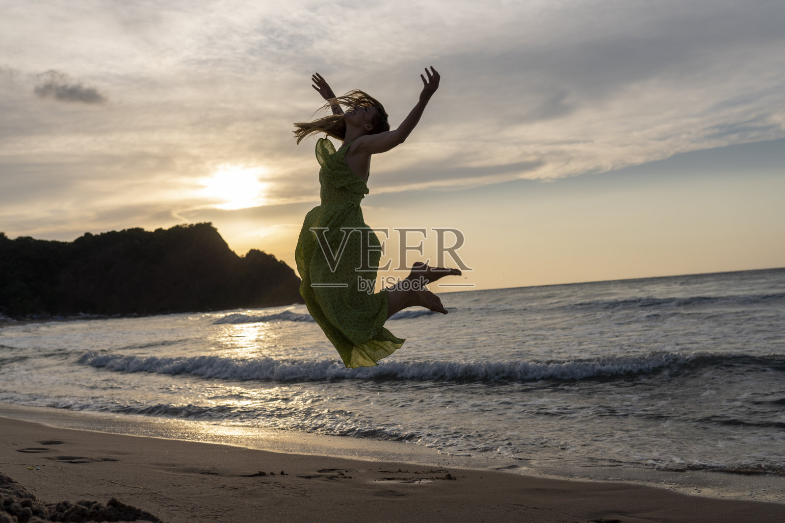 快乐的女人拿着帽子跑着跳着尽情享受海滩度假的生活。沙滩、夏日、liftstyle、积极心情、旅游、放松的概念。照片摄影图片