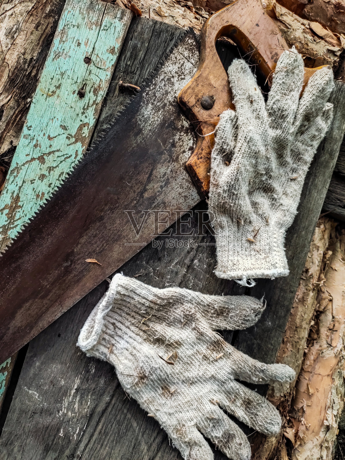 脏手套和旧锯上面棕色和黑色木材材料照片摄影图片