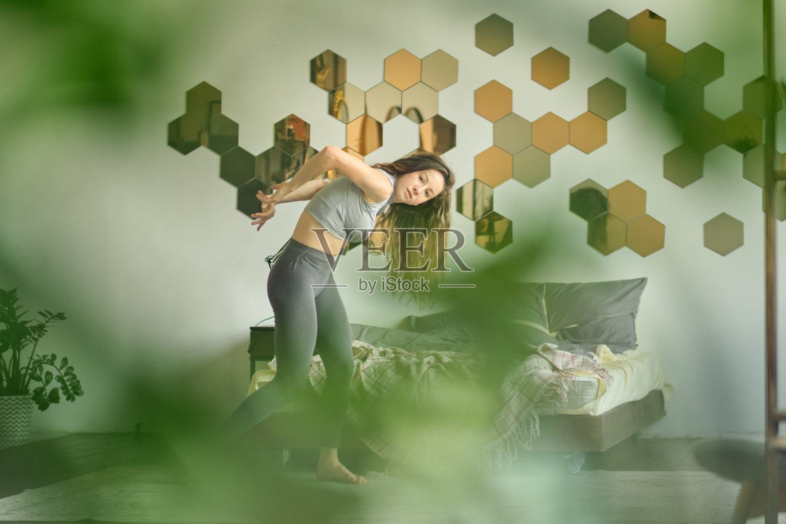 优雅的女子在自己家里跳舞，在舞台上展示自己。快乐女人在家里跳舞享受休闲，压力自由的理念。自由和自我接纳的概念。软的焦点。模糊的散景照片摄影图片