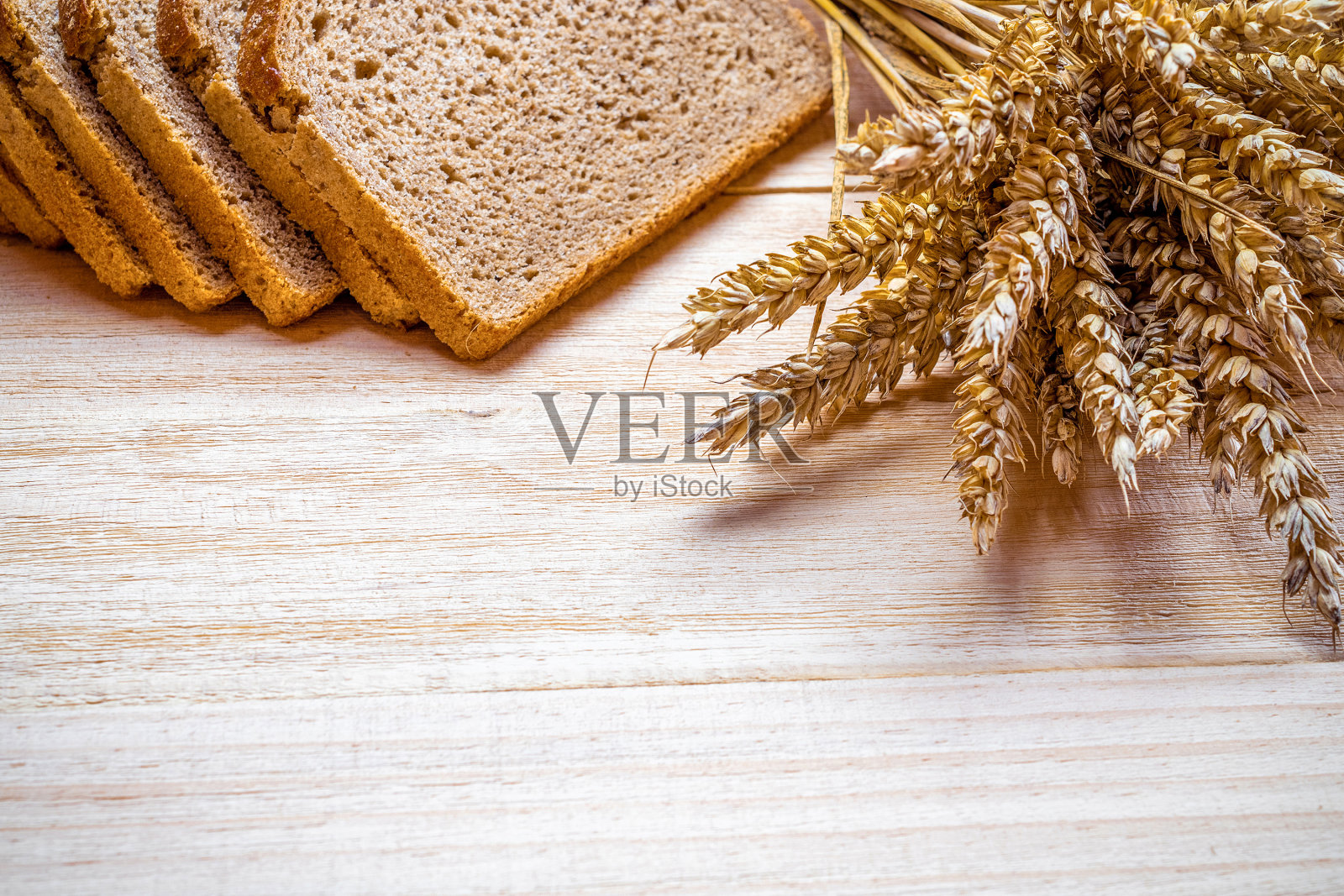面包面包。用硬面包和面包屑做的黑麦面包。新鲜面包的乡村传统面包与小麦穗或穗状植物在自然木制背景。生物成分，非常健康的种子。照片摄影图片