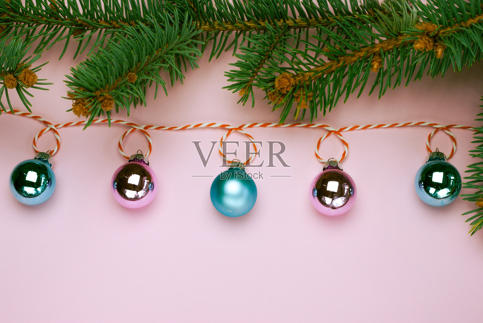 圣诞构图，时尚色彩。粉色和天蓝色的球在粉红色的背景上闪闪发光的圣诞花环横幅照片摄影图片