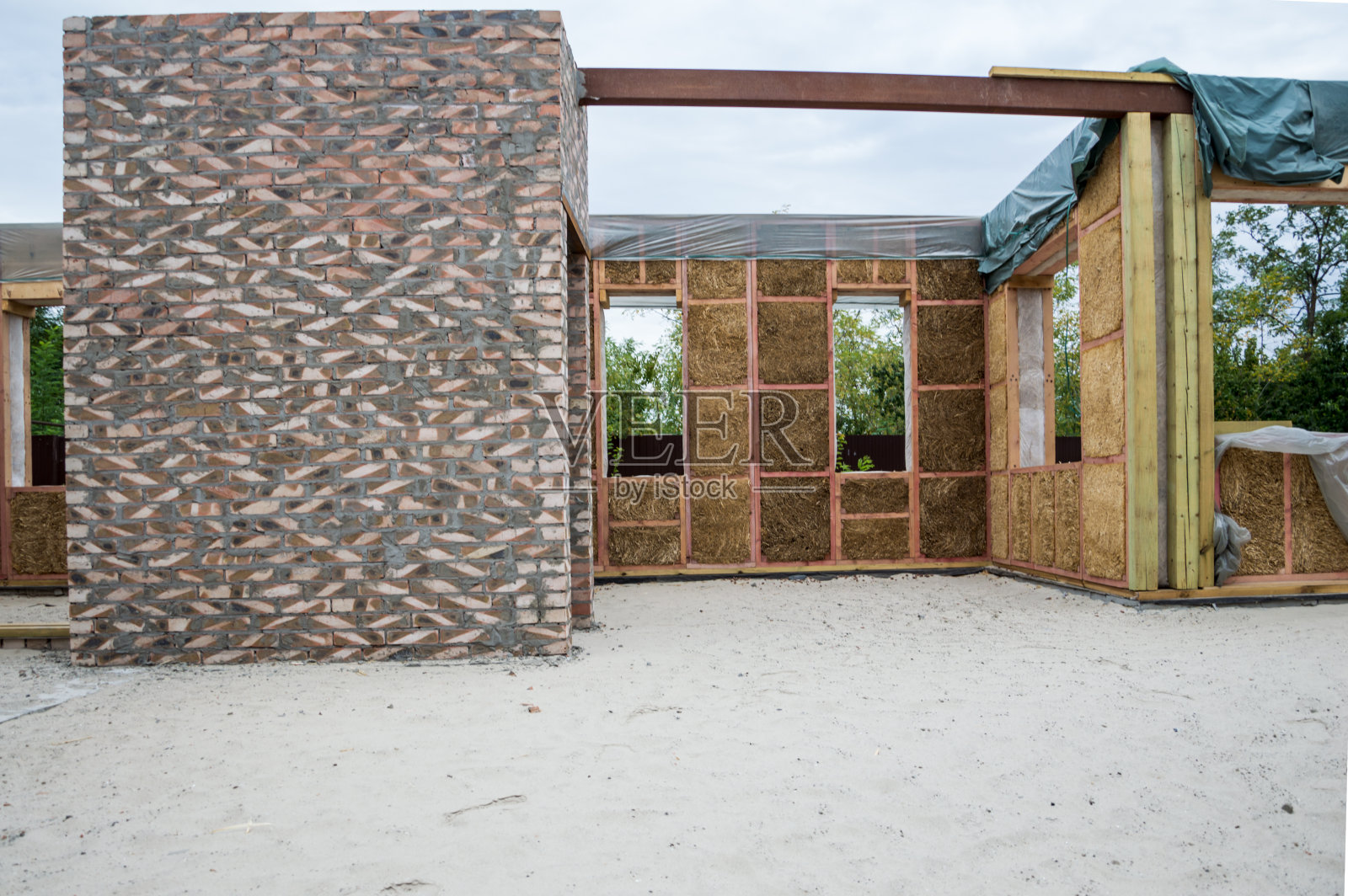 房屋的建设。墙壁是用稻草做的，内部的隔板是用砖块做的，天花板是用黏土和金属支撑的砖块做的。照片摄影图片