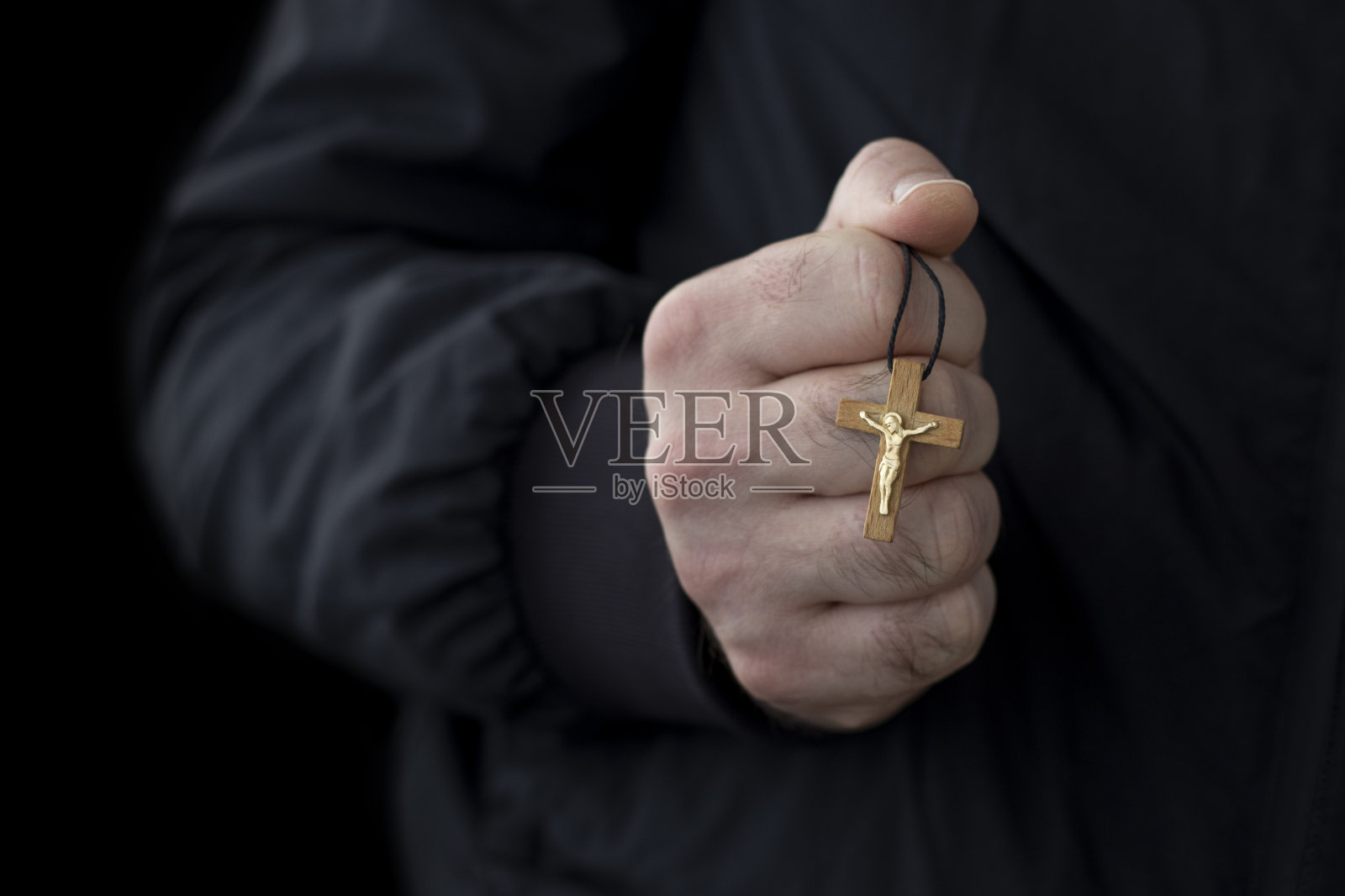 木制十字架在男性的手中。照片摄影图片