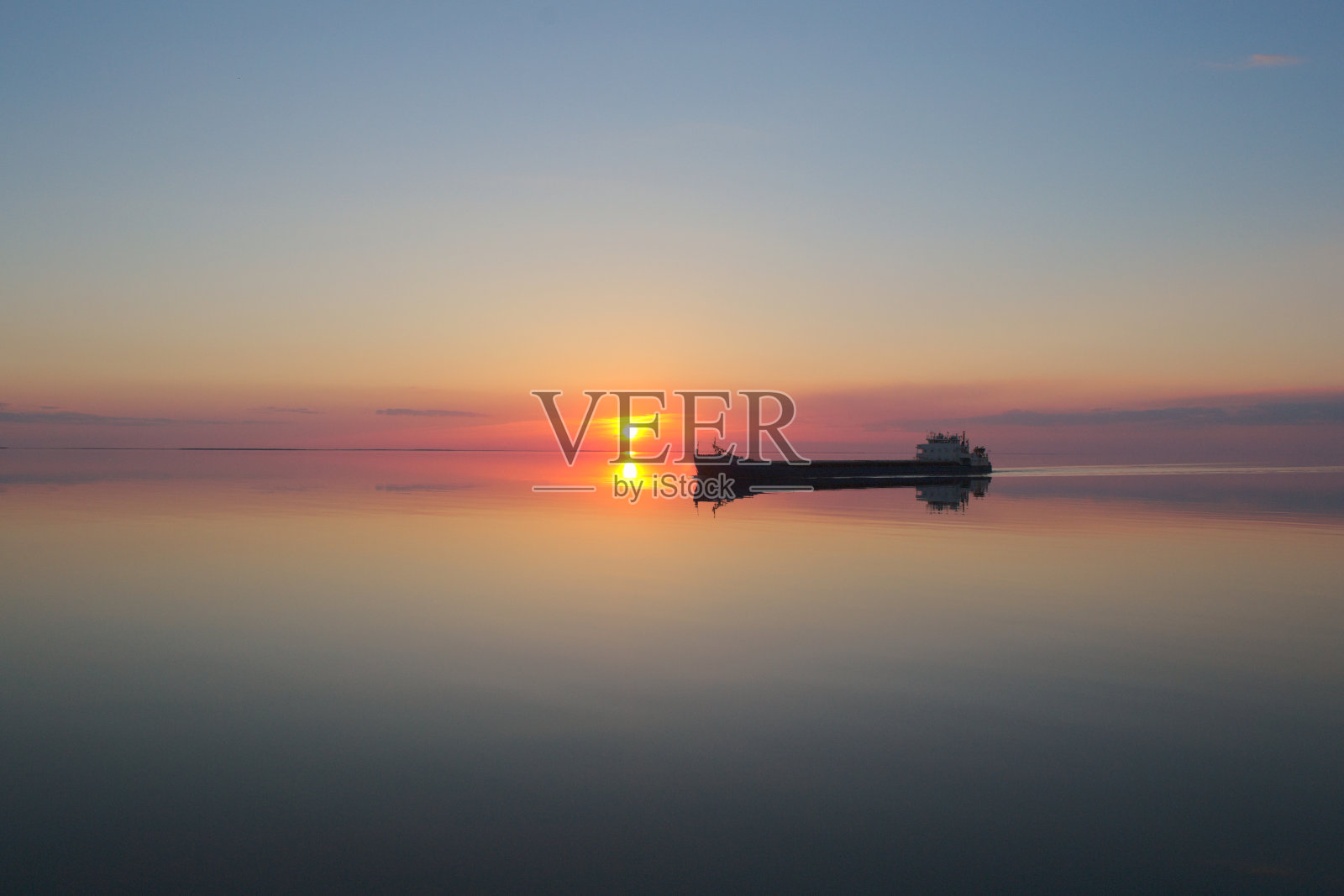 日落时分，湖面上停着一艘驳船照片摄影图片