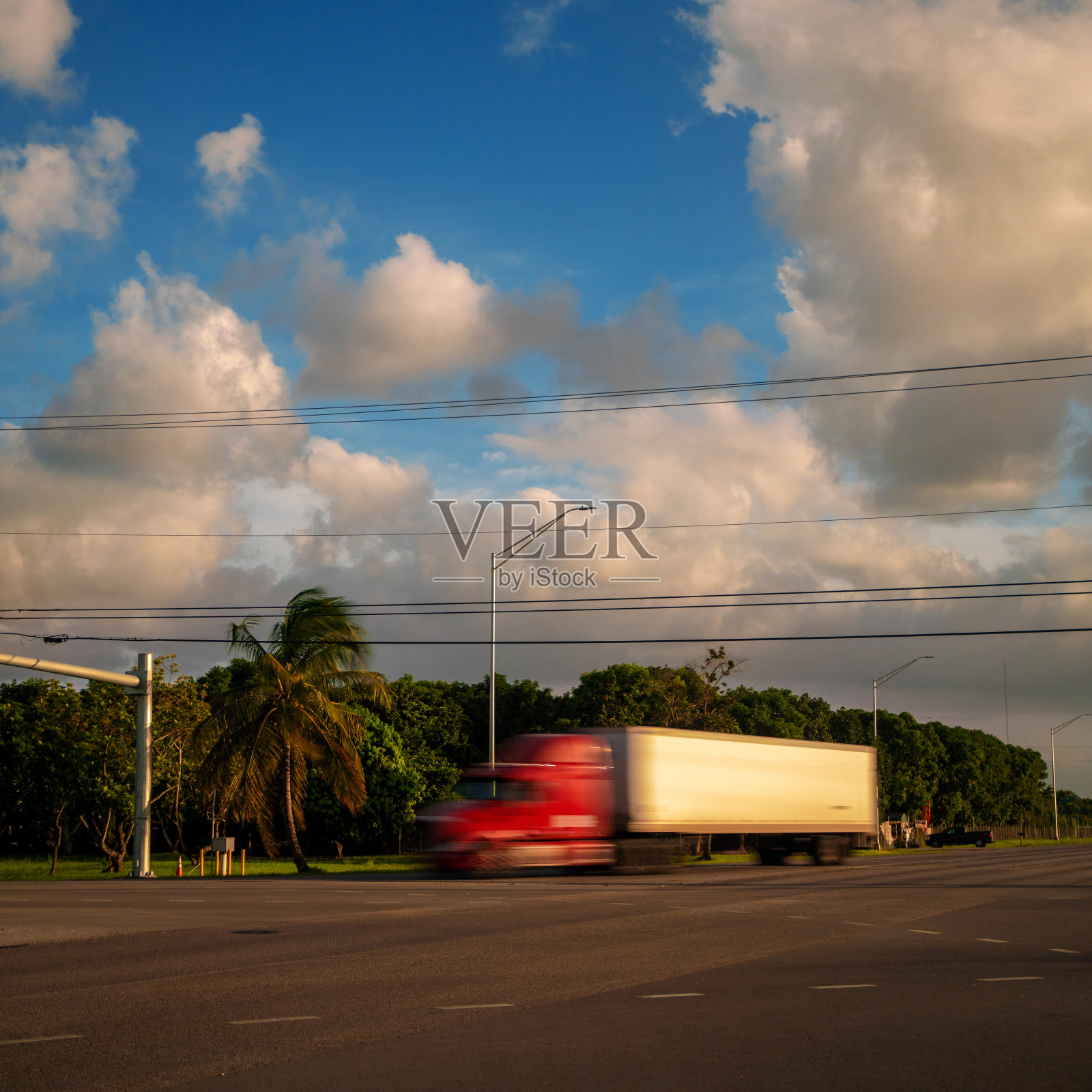 运动模糊日落时红色和白色的半卡车照片摄影图片