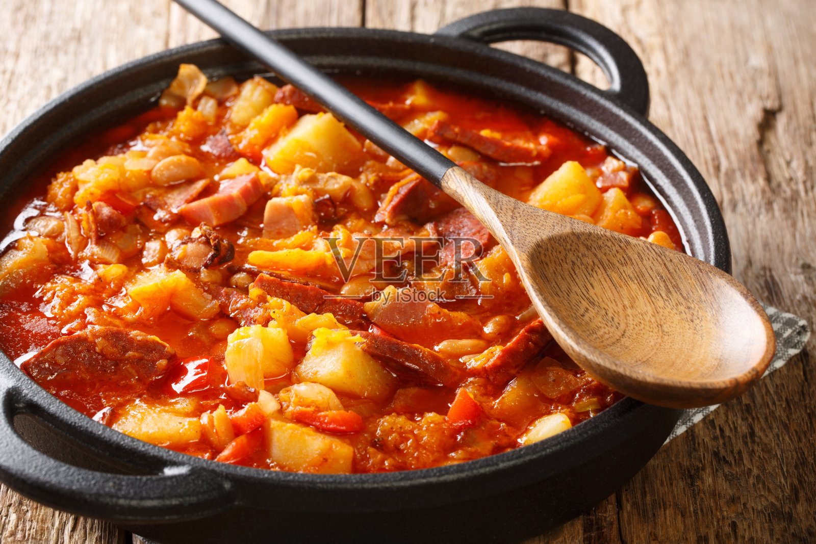 由蔬菜、香肠和肉制成的辣炖乐可近距离放在锅里照片摄影图片