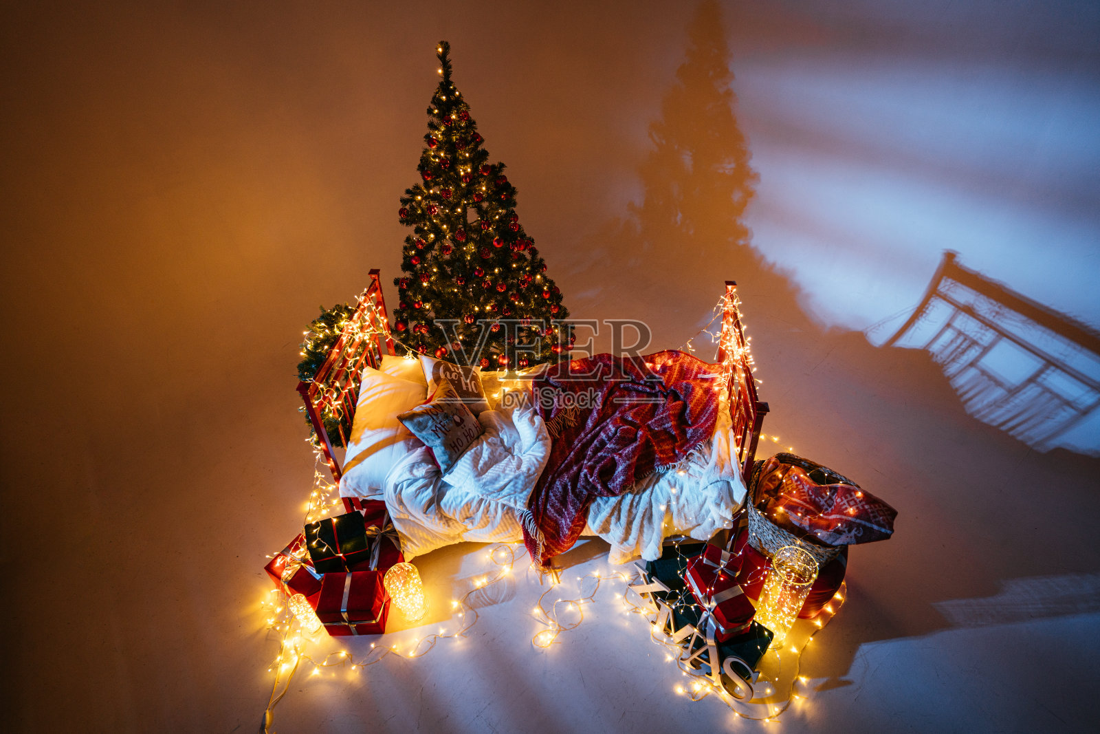 2021年新年室内装饰有蜡烛、灯泡和散焦。房间装饰圣诞节庆祝活动。带礼物的圣诞树照片摄影图片