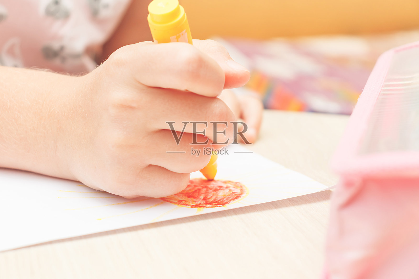 一个男孩和一个女孩正坐在桌子旁边的沙发上，用颜料和毡尖笔画画。照片摄影图片