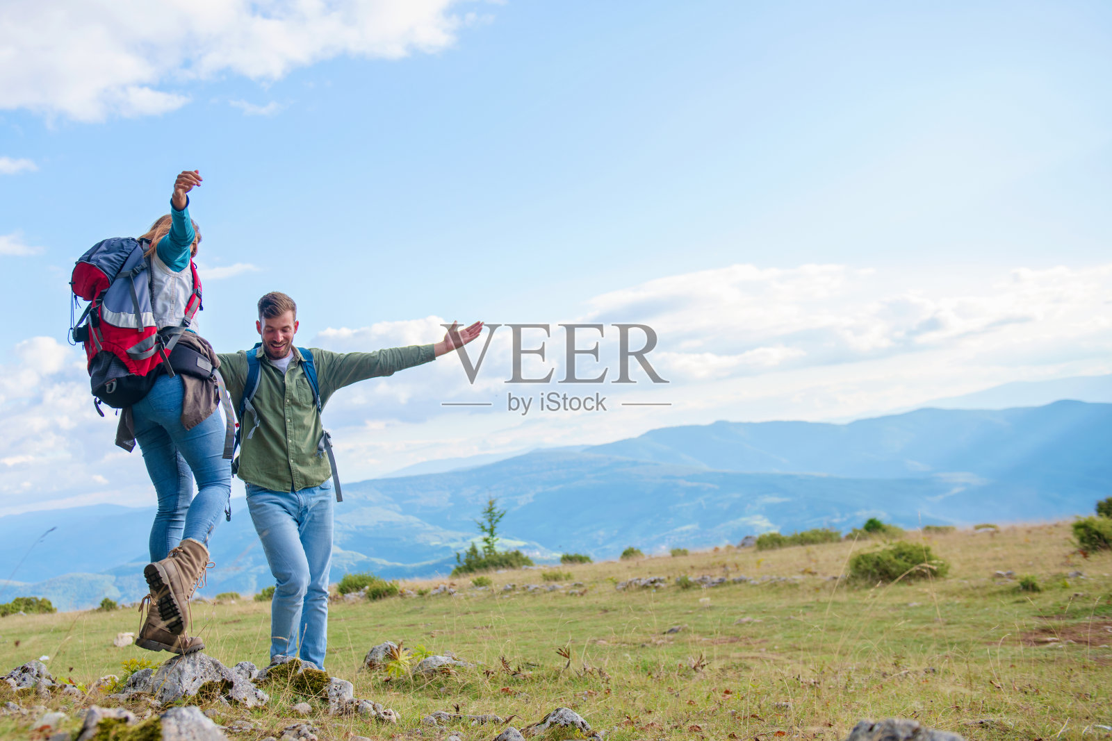 两个背包客站在山顶上看照片摄影图片