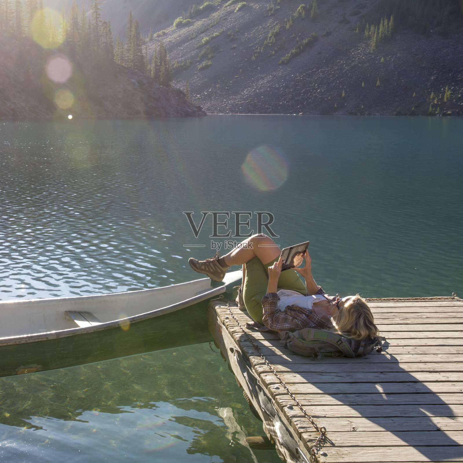 日出时分，女皮划艇运动员在木码头上休息照片摄影图片