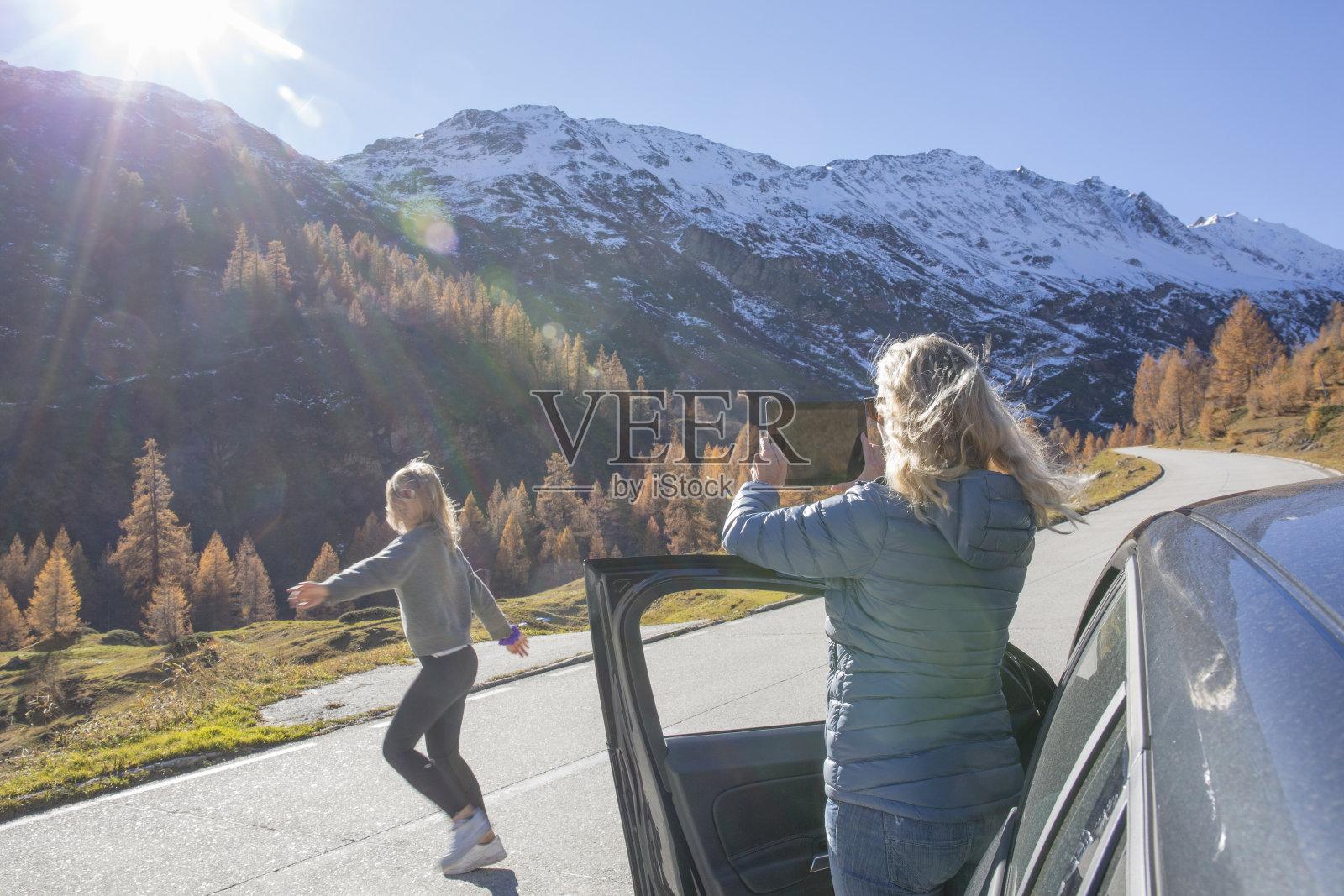 母女俩把车停在阿尔卑斯公路上，在欧洲阿尔卑斯欣赏日出照片摄影图片