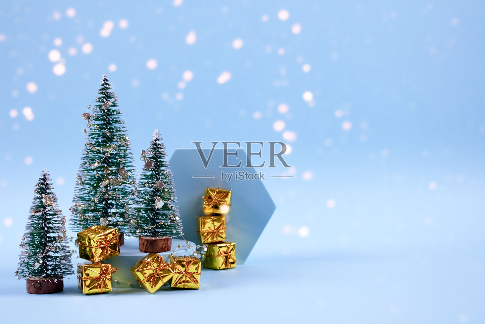 圣诞和新年的组成与新年树，金色的礼物盒，装饰和散景灯在柔和的蓝色背景与copyspace。选择焦点，放置文本照片摄影图片