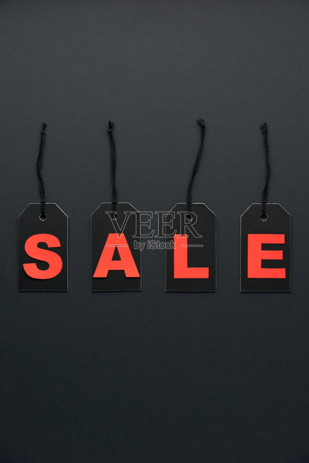 文字销售写在黑色的硬纸板标签或价格标签，与电线隔离在黑暗的背景。BlackÂ周五，购物，销售和营销的概念。俯视图，平放，复制空间。照片摄影图片