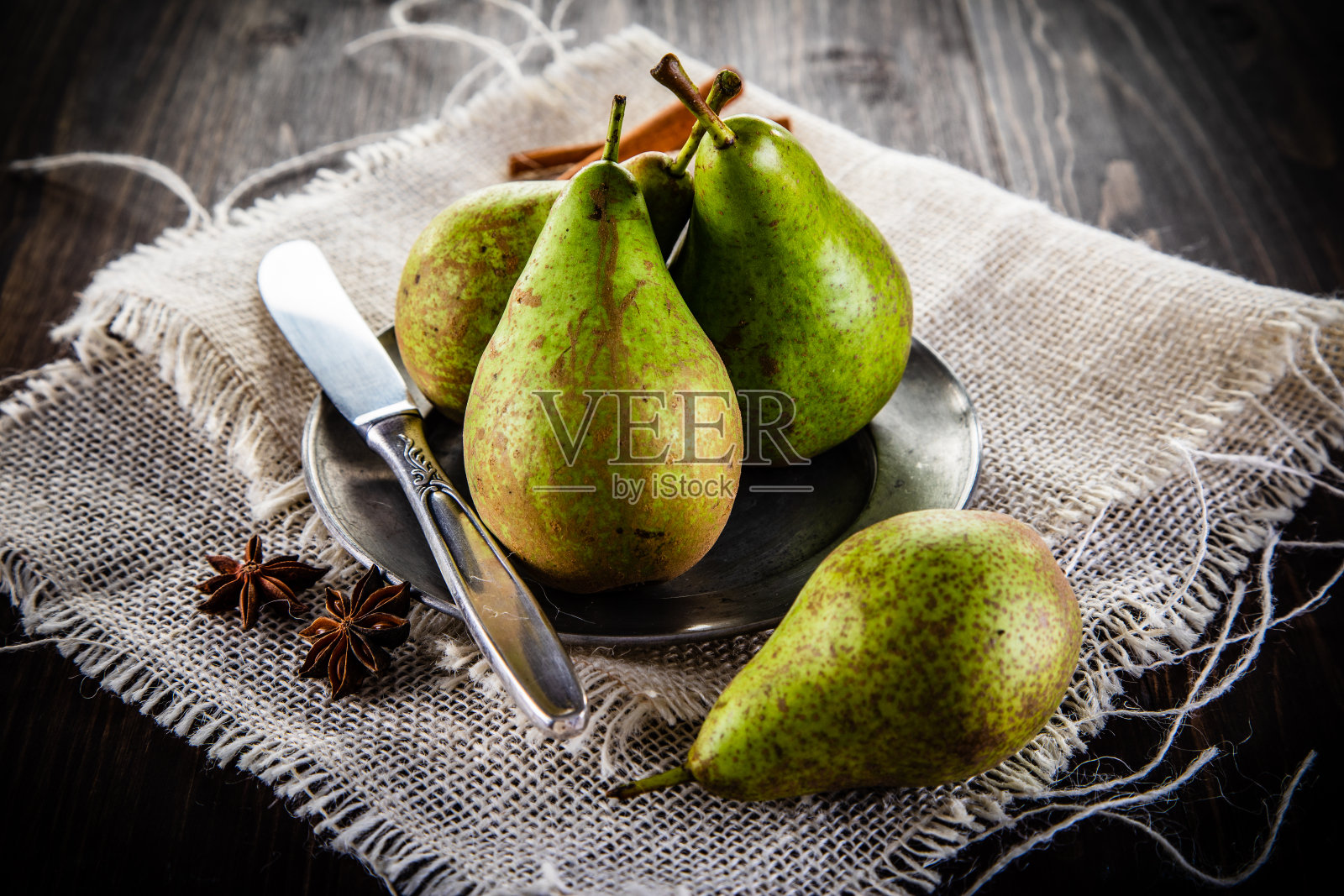 梨子配肉桂和丁香放在木桌上照片摄影图片