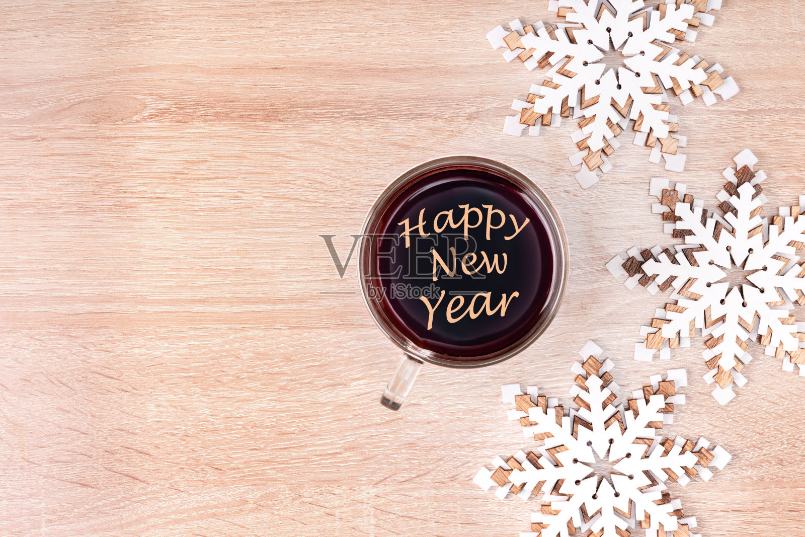 新年快乐写在一杯咖啡和木制装饰在书桌上。顶部视图与复制空间。照片摄影图片