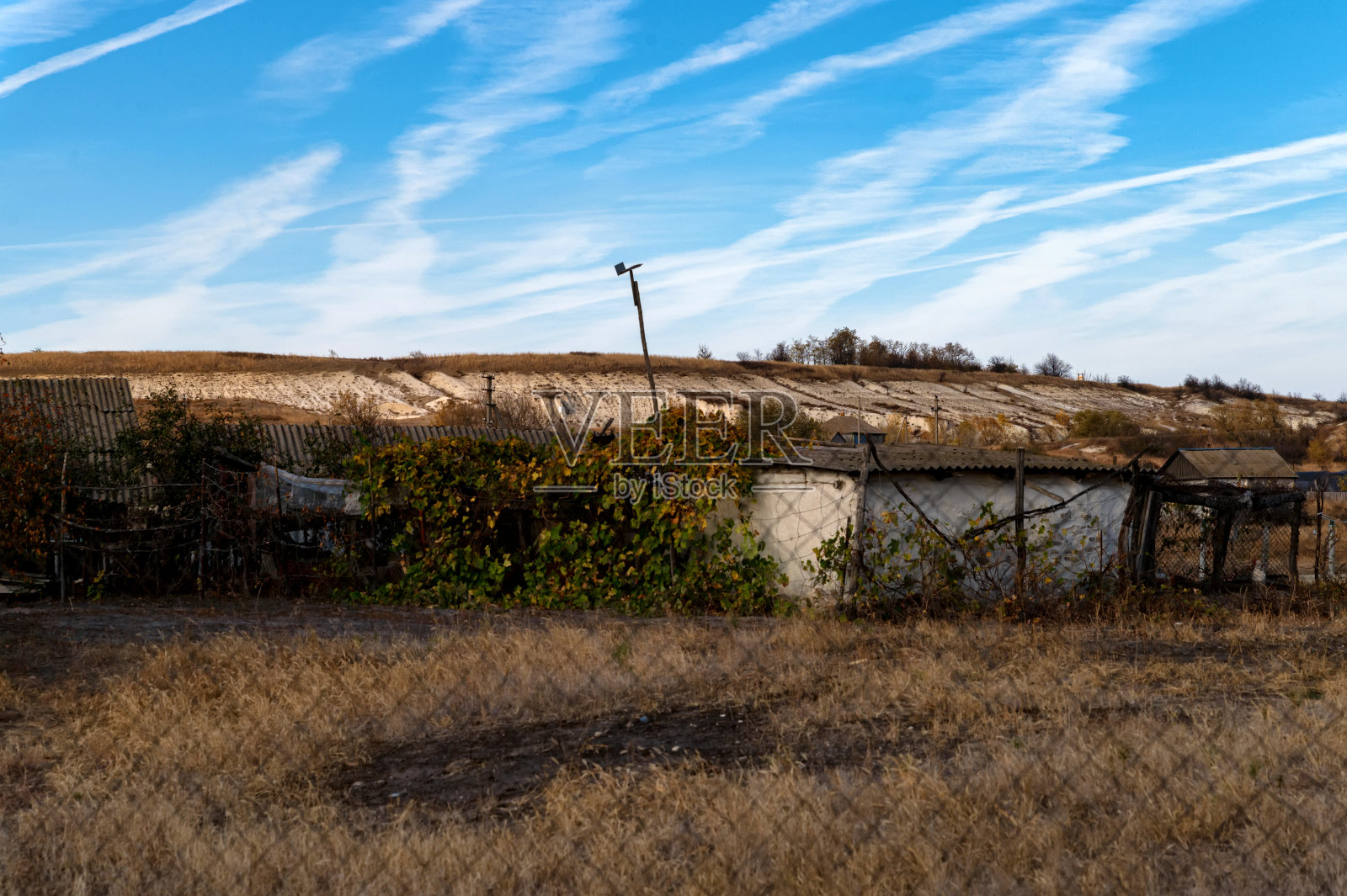 一个古老的宅基地和被篱笆包围的小木屋。照片摄影图片