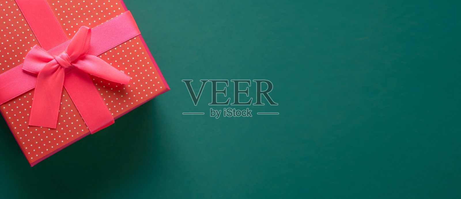 绿色背景上的小红礼盒，复制空间照片摄影图片