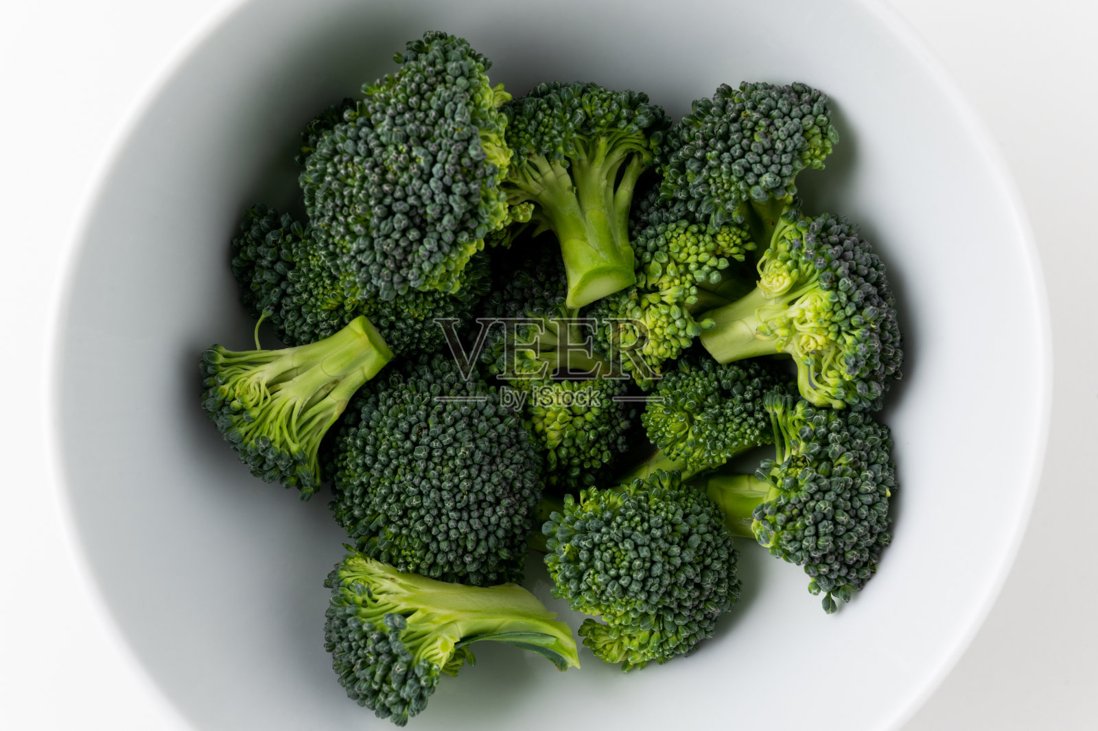 新鲜健康的蔬菜和食物。生花椰菜切成小块，放在白色碗底。照片摄影图片