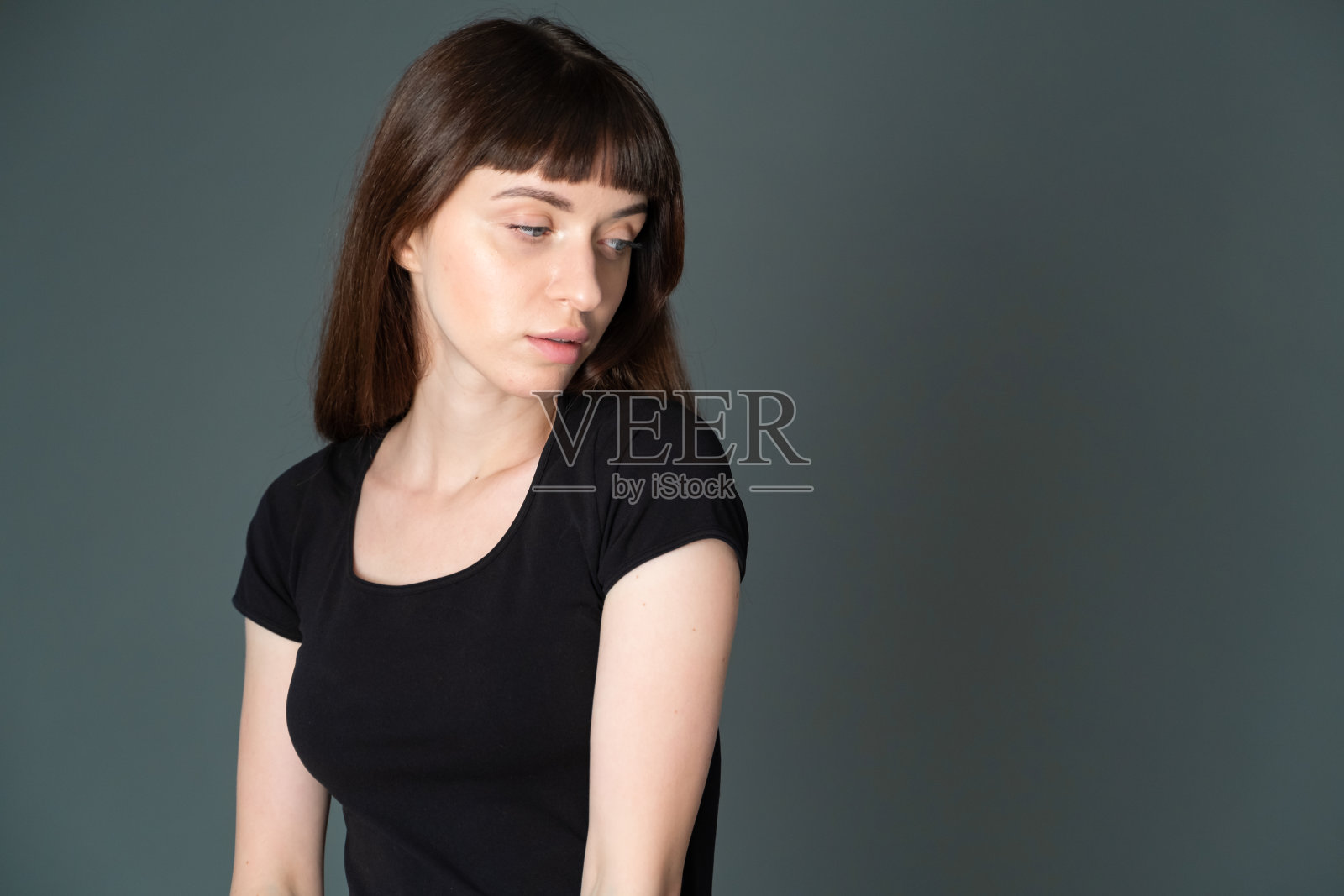 一个年轻女子的画室肖像，背景是纯黑色照片摄影图片