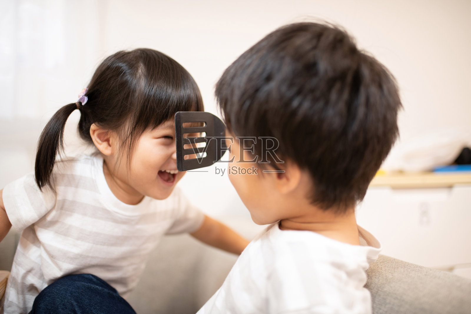 孩子们，妹妹和弟弟，在厨房玩抹刀的特写照片摄影图片