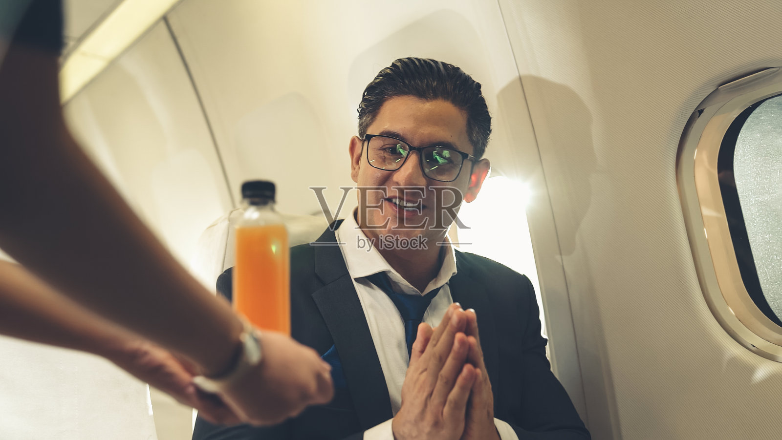 商人在飞机上有空中小姐提供橙汁照片摄影图片