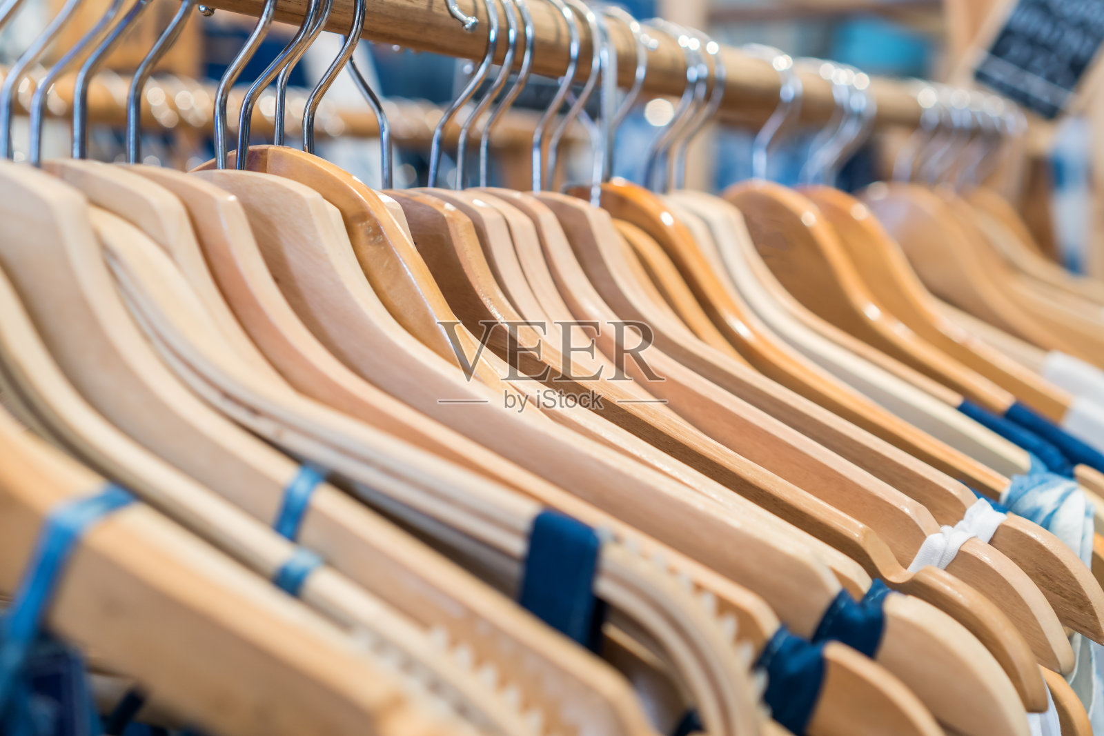 女士服装上的木制衣架在货架时尚出售在店面，零售背景。照片摄影图片
