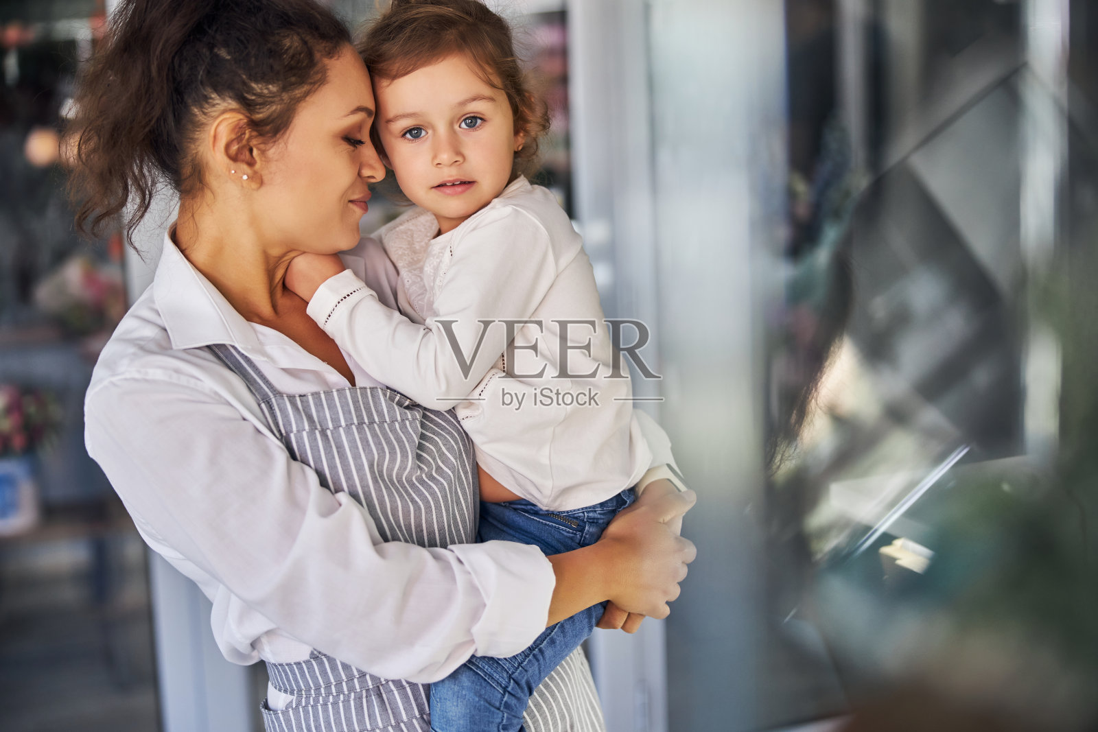 慈爱的母亲把孩子抱在怀里照片摄影图片