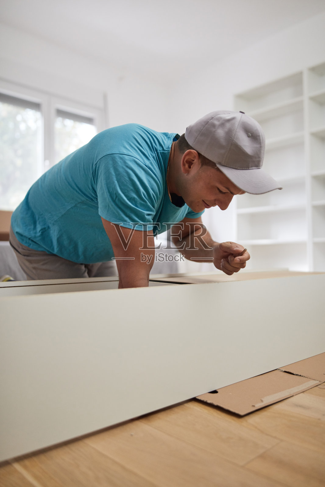 男人在新公寓组装家具，搬进来工作。照片摄影图片