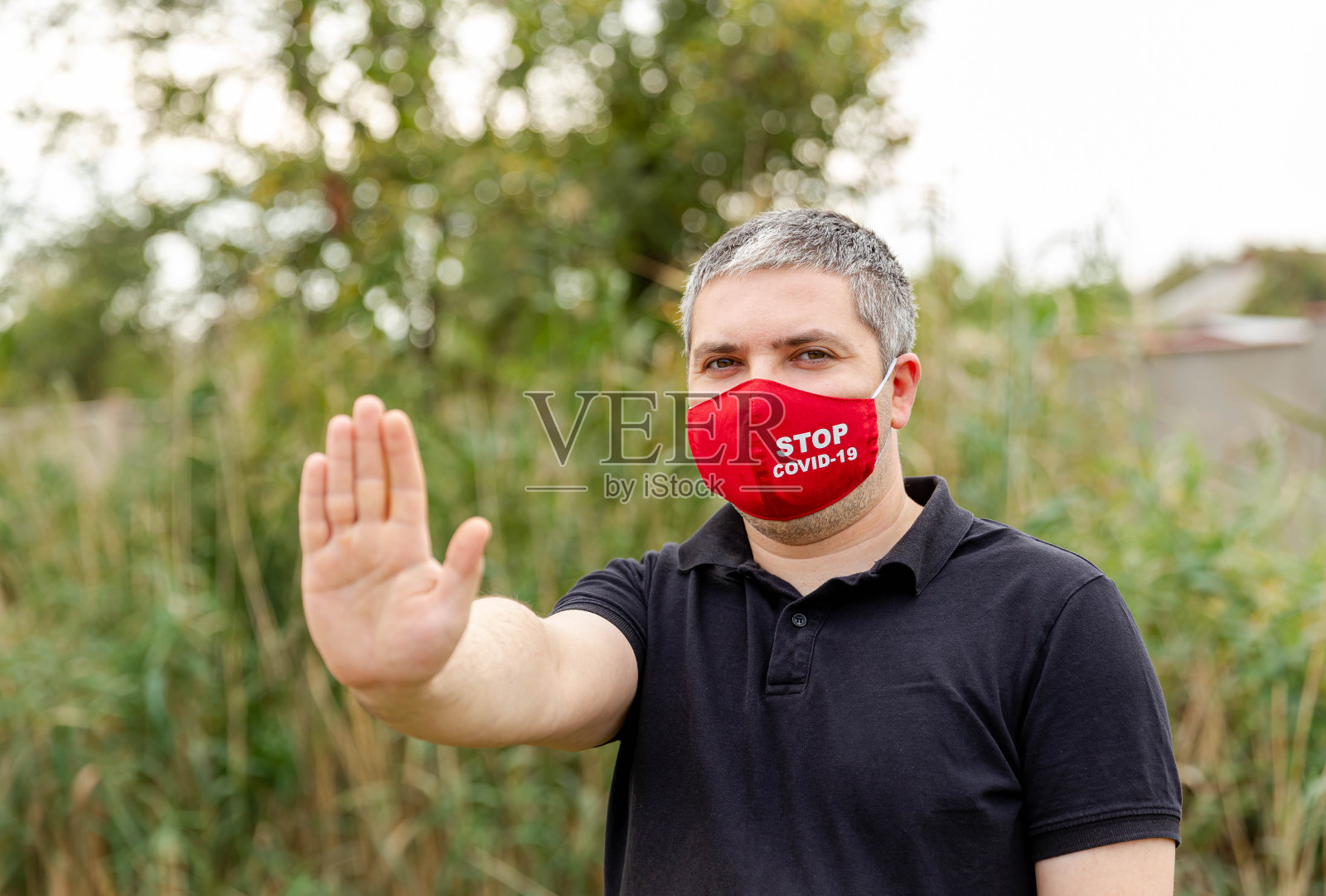 用防护口罩遮住脸以防止病毒感染的男子照片摄影图片