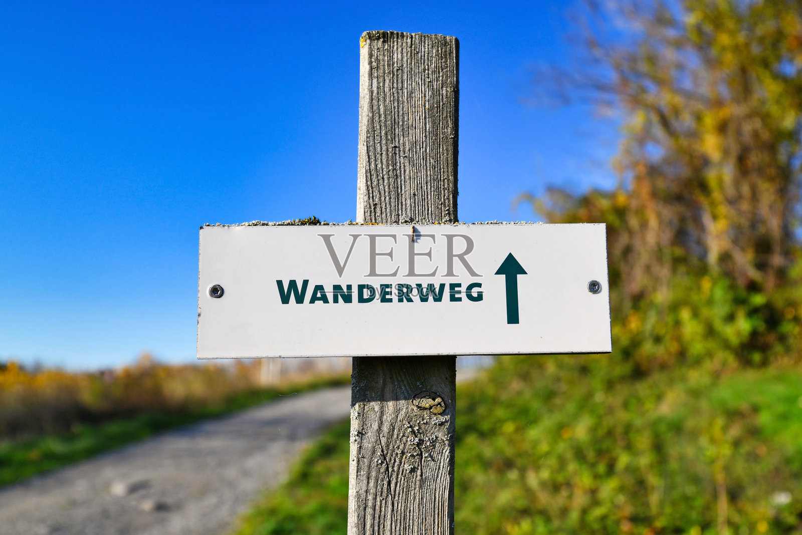 木杆上的标牌用德语写着“徒步旅行路线”照片摄影图片