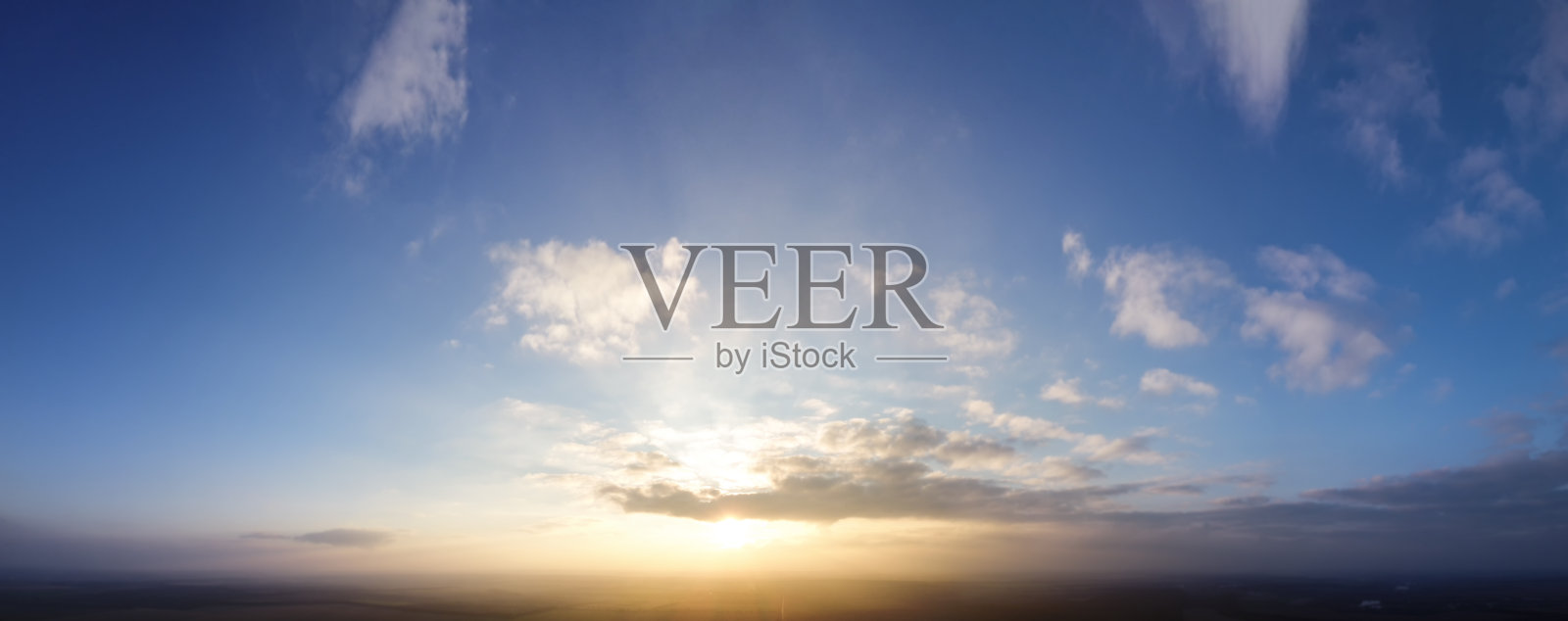 蓝天和夕阳，小云绕太阳。照片摄影图片