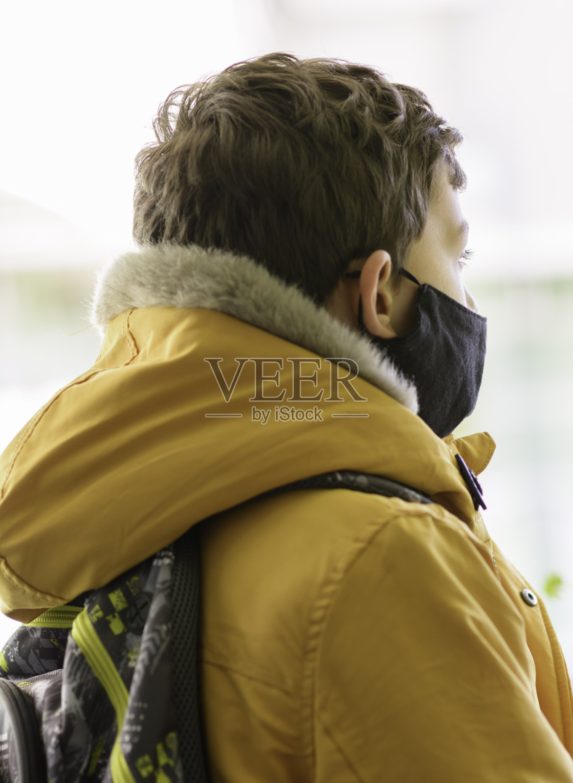 带着防护面具上学的漂亮男孩照片摄影图片