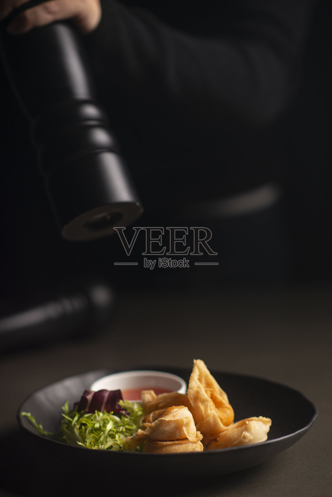 特写男厨师使用黑胡椒研磨机照片摄影图片