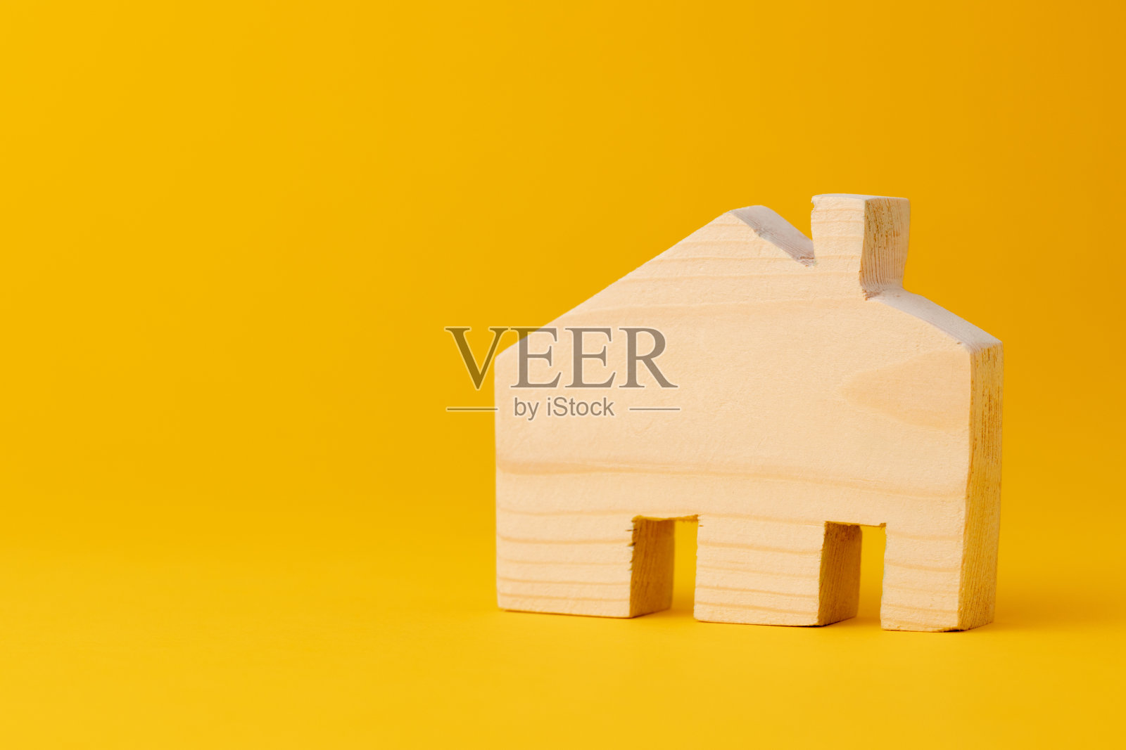黄色背景上的木制迷你房子模型照片摄影图片
