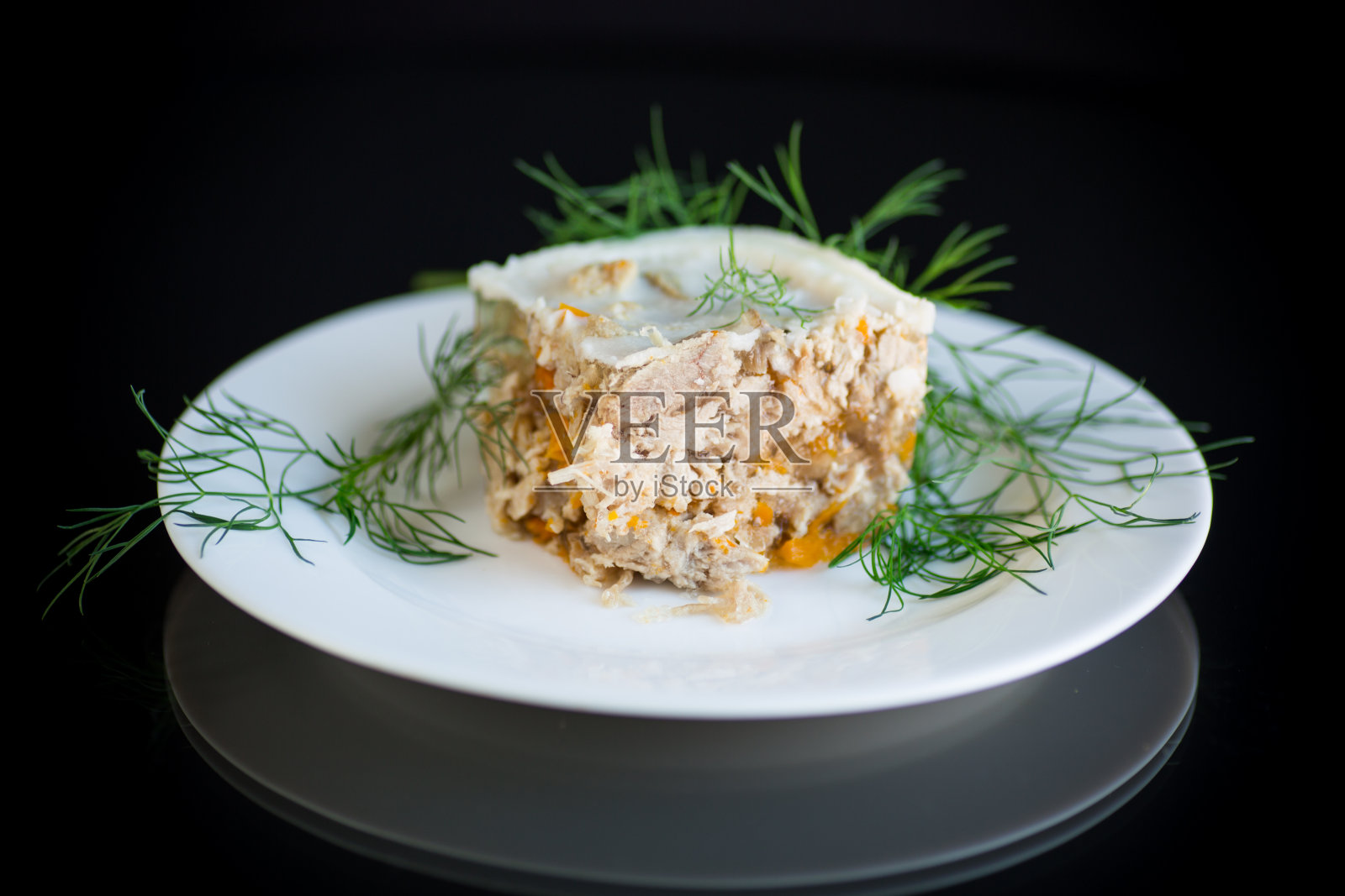 在黑色背景的盘子里的一片冷冻肉冻照片摄影图片