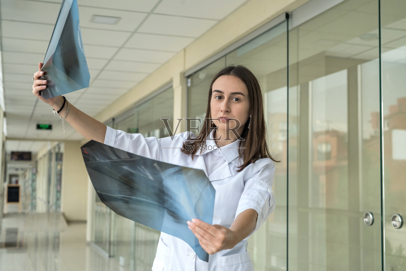 年轻女性肺科医生检查并检查胸部x线扫描，检查COVID-19患者肺部照片摄影图片