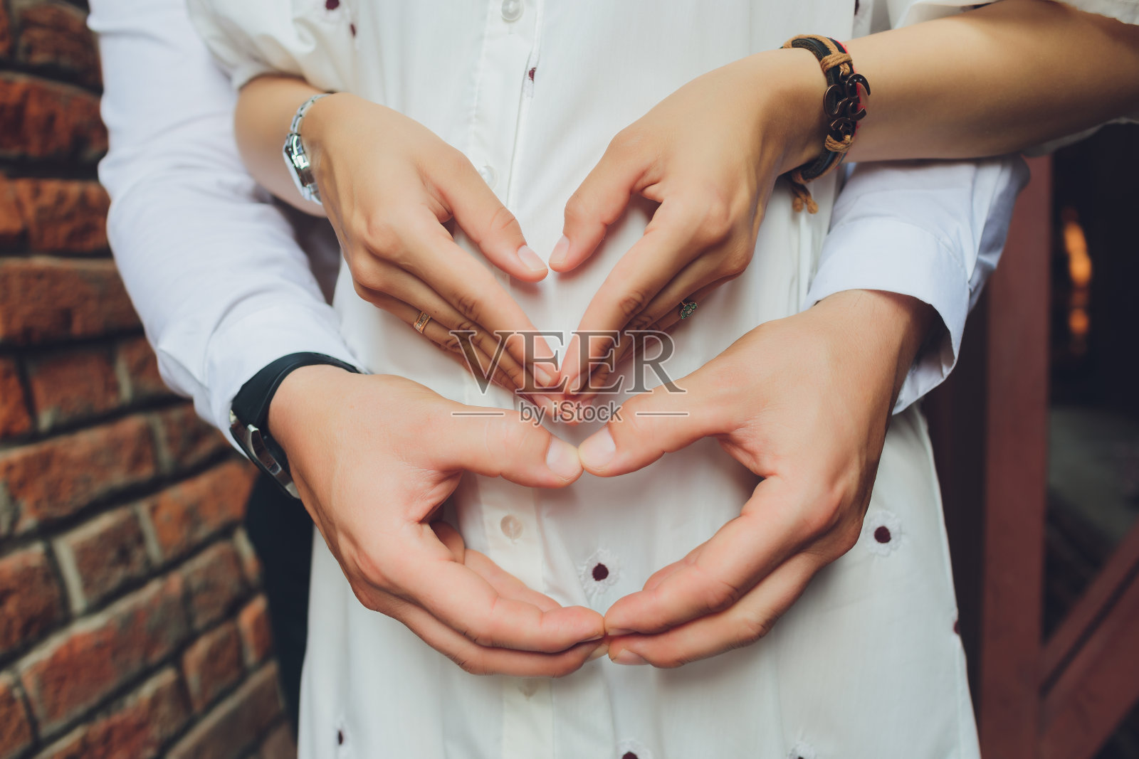 一对夫妇用手做心形的特写。照片摄影图片