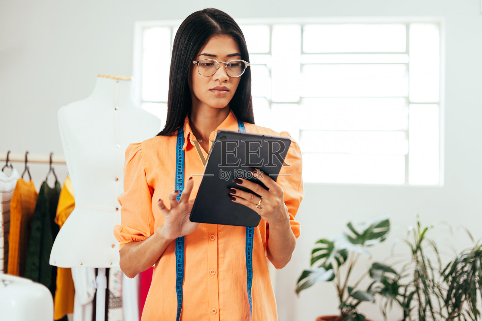 一个巴西妇女在她的缝纫工作室工作。创业拉丁女子。照片摄影图片