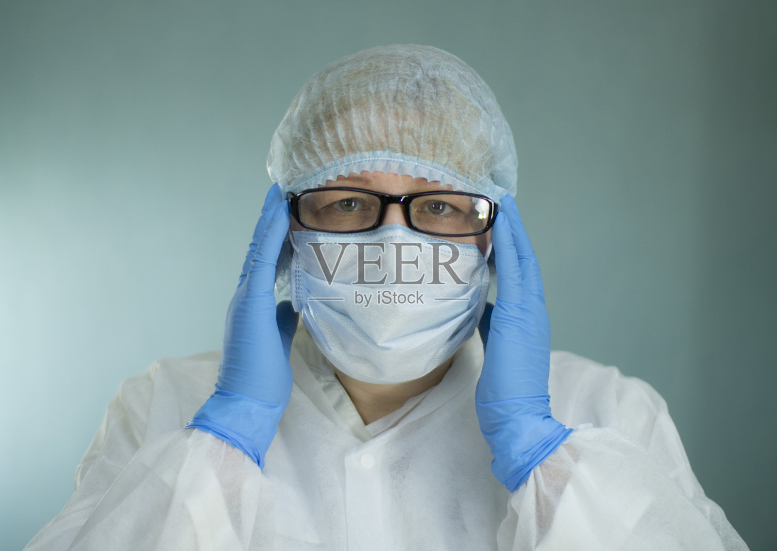 一个疲惫的医生戴着医用面具的肖像。照片摄影图片