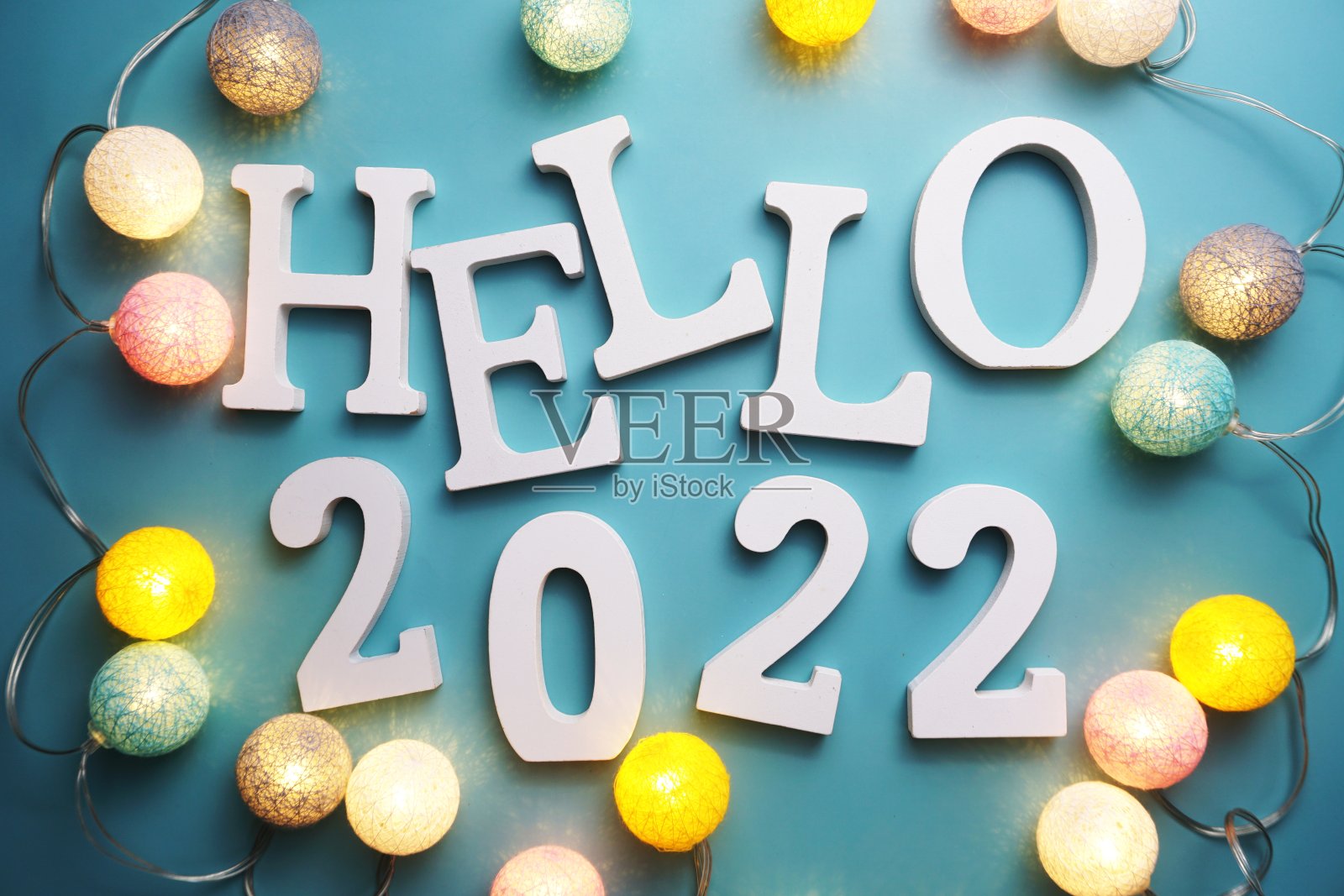 你好2022字母与棉球LED装饰在蓝色的背景照片摄影图片