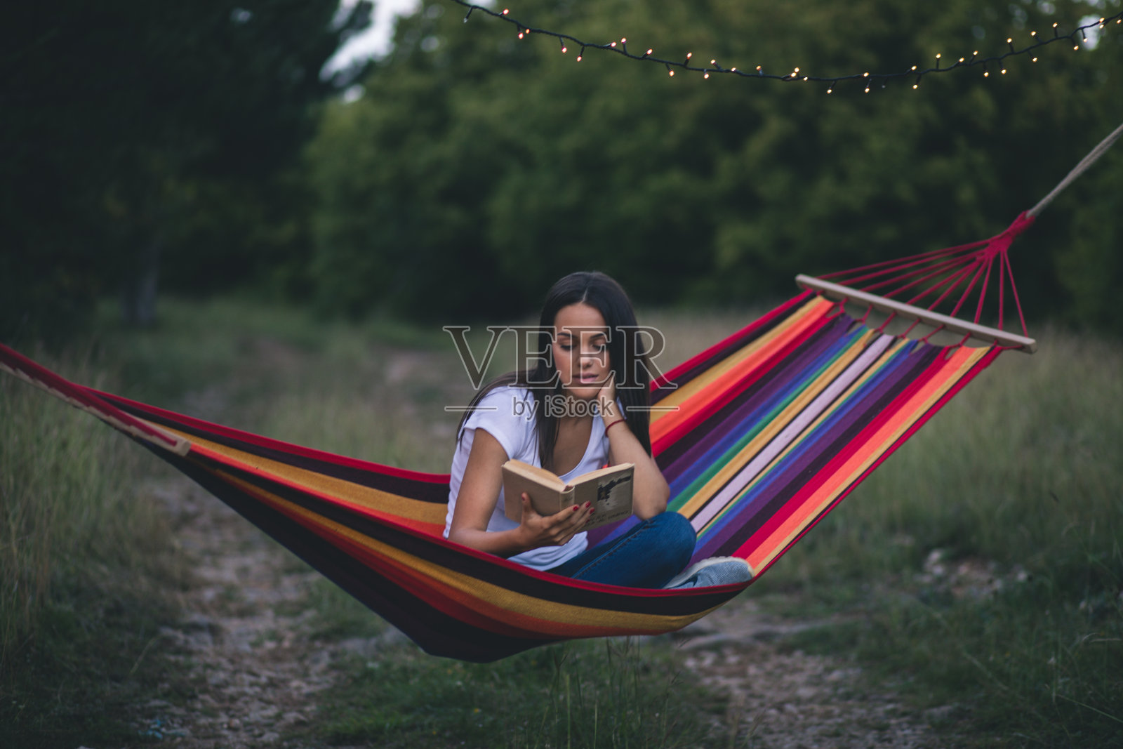 美丽的年轻女孩躺着看书照片摄影图片