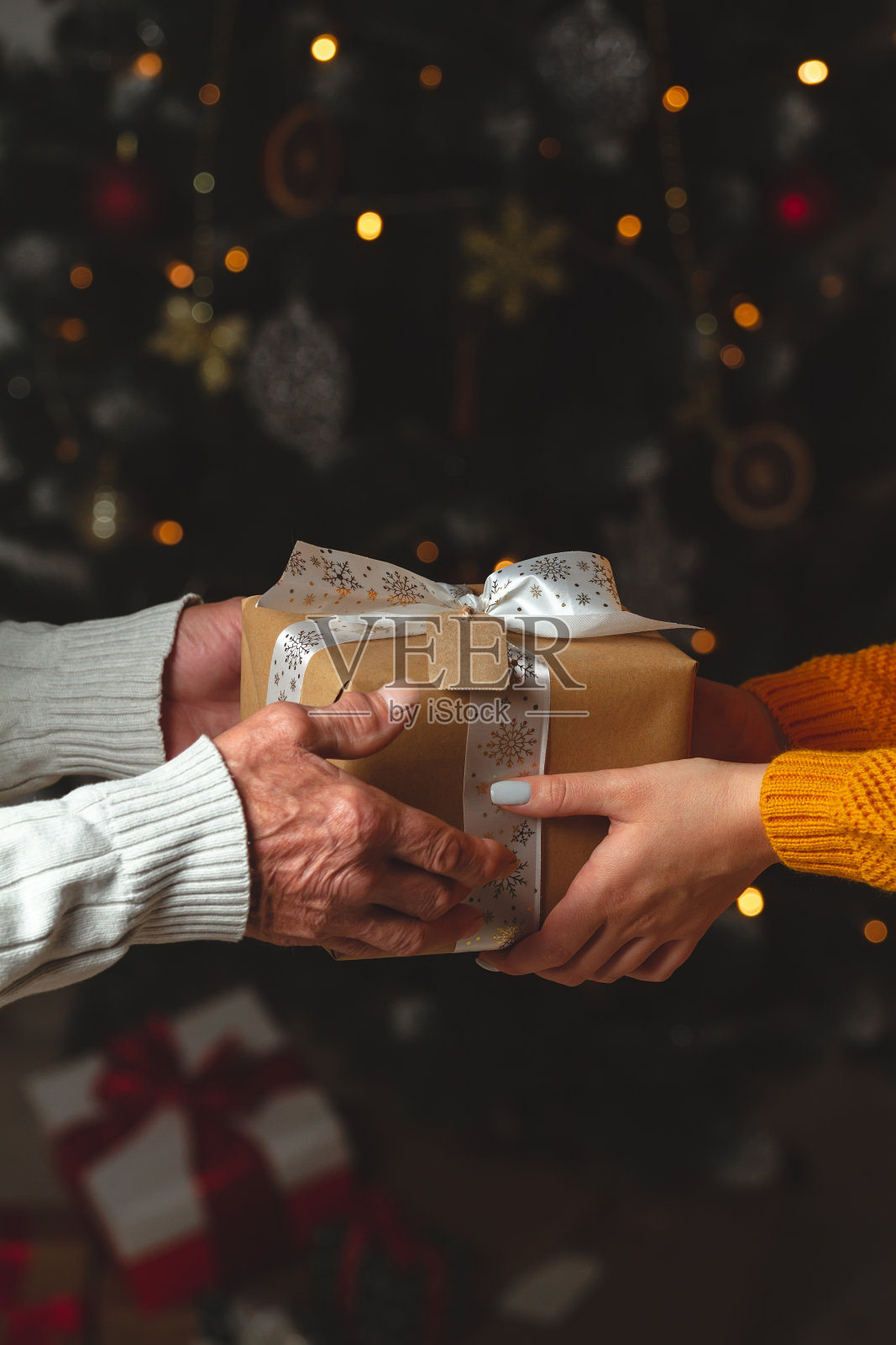 一位年长的先生和一位年轻的女士给了一个圣诞礼物照片摄影图片